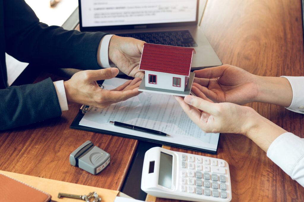 Home agents are giving house gifts to new home buyers in office room.